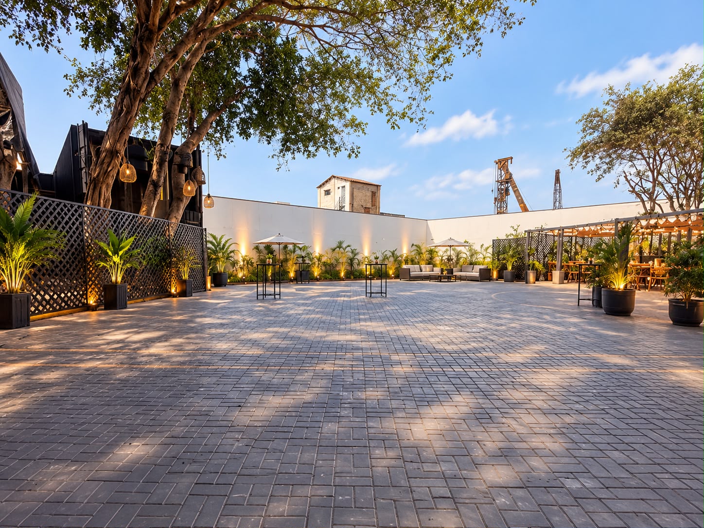 Vista del patio abierto de La Estación, con árboles, vegetación y mesas
